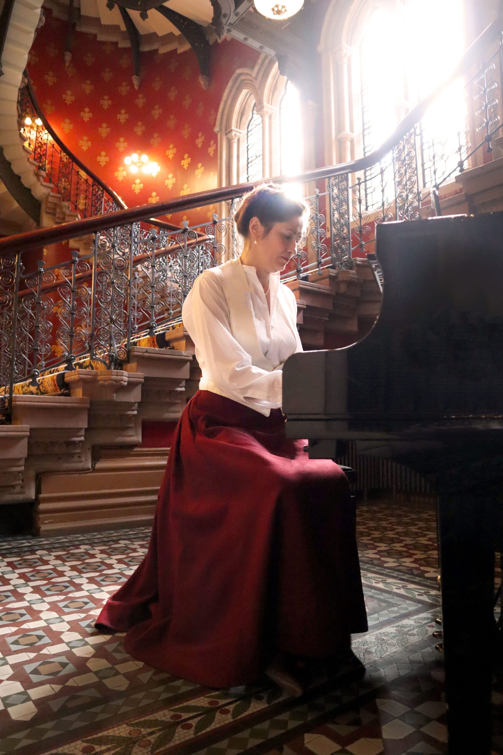 Cathy Hay in a red walking skirt, pretending to play the piano